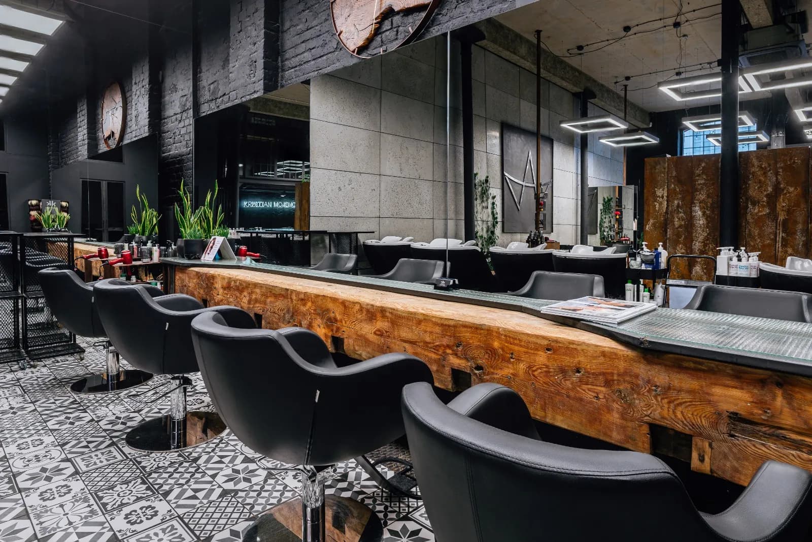 Wnętrze salonu Krystian Wojewoda Hair Design w Łodzi — stanowiska fryzjerskie przy drewnianym blacie